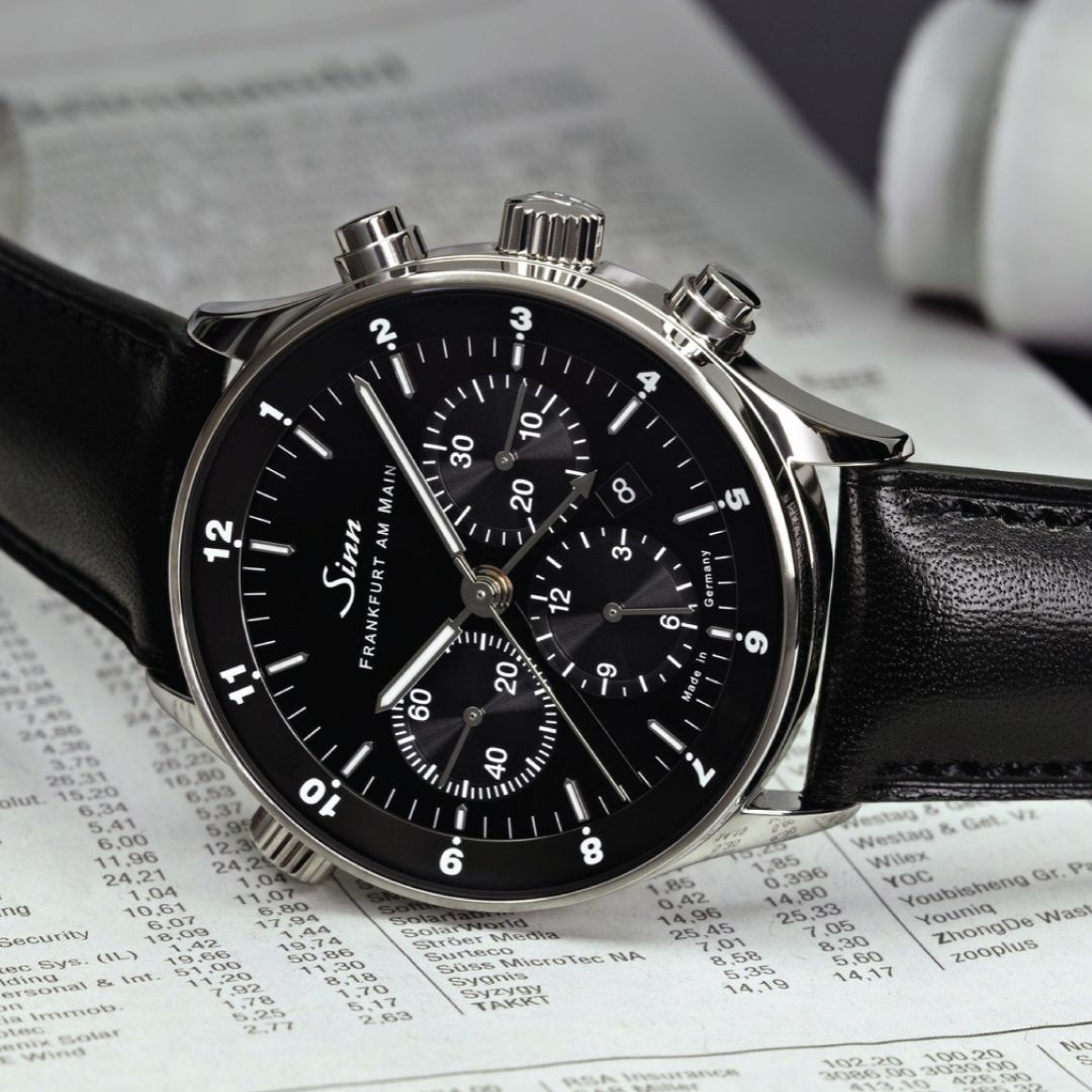 Front view of SINN 6099 watch with black dial, leather strap, and date display.